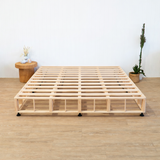 Wooden Naptime bed frame on a wooden floor with minimal decor