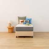 Naptime mattress and bed base with colourful pillows in a minimalistic room