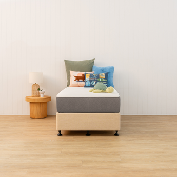 Naptime mattress and bed base with colourful pillows in a minimalistic room