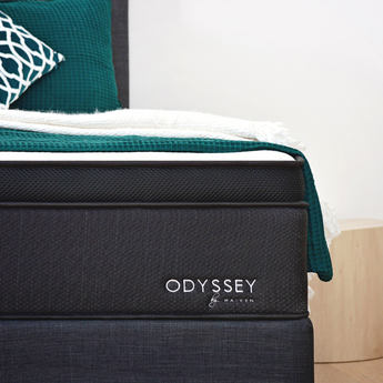 Close up of Odyssey mattress with green and white throws