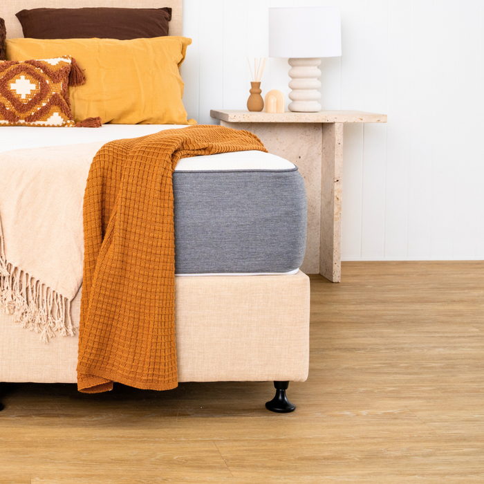 corner angle of mattress and bed base with pillows and a throw