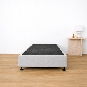Light grey bed  base on timber floor with side table 
