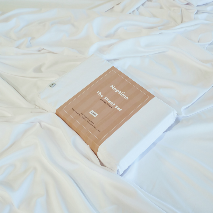 Neptune sheet set packaging on a white bedspread