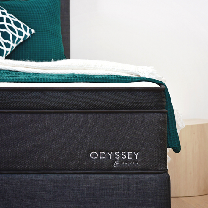 Close up of Odyssey mattress with green and white throws 